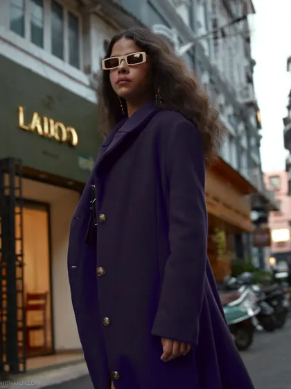 A low-angle shot that gives the portrait a powerful, larger-than-life feel. The urban environment becomes a dynamic stage for this fashion story.