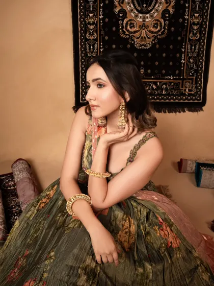 An elegant e-commerce shot for an ethnic wear brand. The model's relaxed pose and the warm, inviting set design create an aspirational lifestyle image.