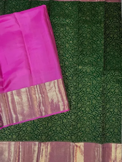 This pure Kanjivaram silk saree features a stunning green brocade body paired with a vibrant pink contrast border and pallu. The intricate weaving and rich colors make it a perfect choice for weddings and grand celebrations.