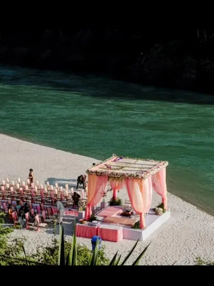 A beautiful shot of a wedding mandap set up on the sandy banks of the Ganga river in Rishikesh, ready for a serene destination wedding ceremony.