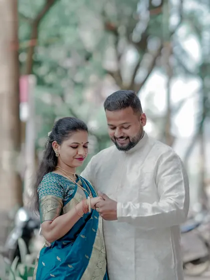A simple and sweet moment between a couple in traditional attire. The groom-to-be gently holds his partner's hand, showcasing their bond.