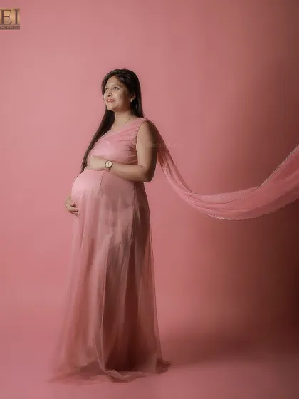 The sheer fabric of this pink gown catches the air, adding a touch of elegance and movement to this studio shot.
