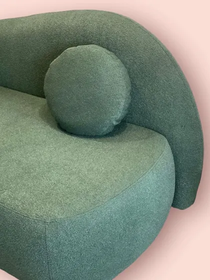 A detail of the 'Baymax' sofa's curved back and soft bouclé texture. It’s designed to be a cozy corner you can sink into.
