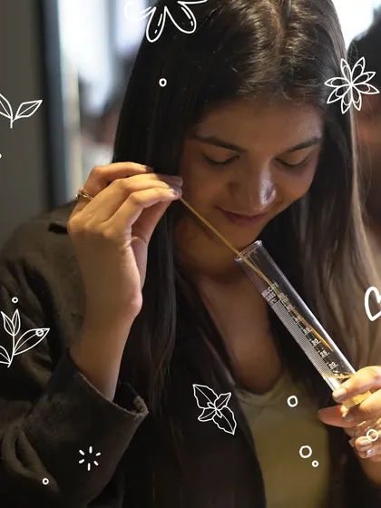 The final test. A participant smells her creation, a blend of science and artistry. This is the moment where all the different notes come together to form a complete, personal scent.