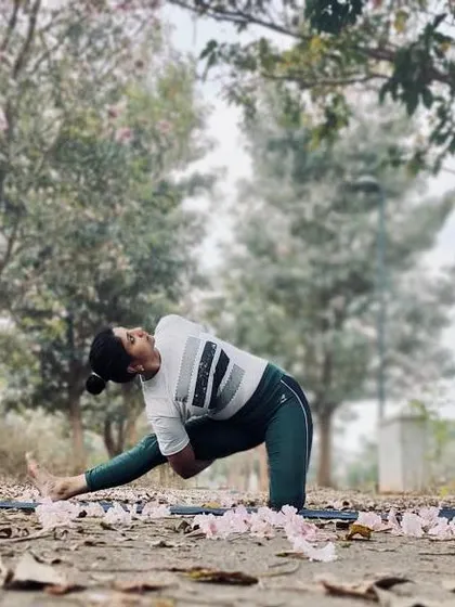 A deep side lunge stretch amidst fallen flowers. You cannot always control what goes on outside, but you can always control what goes on inside.