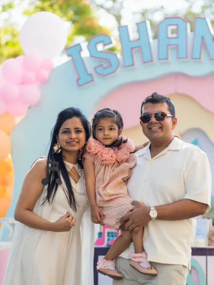 A heartwarming family photo captures the joy of Ishanvi's musical birthday celebration. The custom backdrop and themed decor create a perfect setting for this cherished memory.