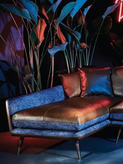 The unique material combination of the Volta Sofa is highlighted here. The rich brown leather and textured blue fabric create a dynamic and luxurious feel, true to the collection's avant-garde spirit.