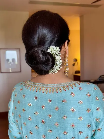 The elegance is in the details. A classic, neat bun adorned with fresh flowers perfectly complements her serene and simple makeup look for the Anand Karaj ceremony.