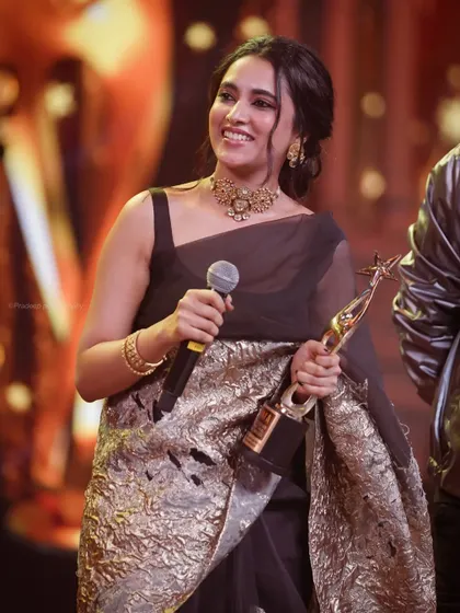 Actress Priyanka Mohan smiling on stage while accepting an award. This photo captures the joy and pride of the moment, a key part of any awards night coverage.