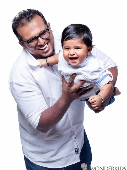 The pure happiness of a father and son playing together. This classic studio portrait on a white background captures a beautiful, candid moment of laughter.