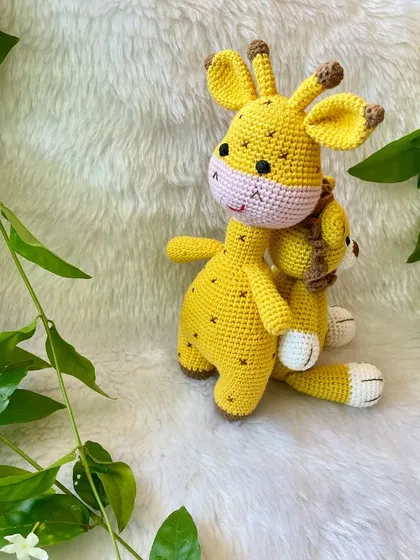 The giraffe and lion plushies sitting together. They make a perfect gift set for a safari or jungle-themed nursery.