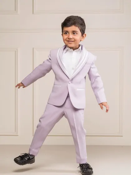 A playful shot of the lilac tuxedo, showing how the custom tailoring allows for comfort and movement. The bright color makes it a fun choice for a designer birthday suit.