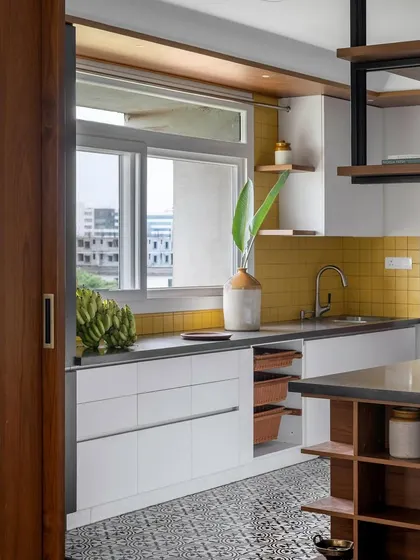 This view shows the 'Vasudhalayah' kitchen's connection to the utility area, with sliding wooden doors providing flexibility.