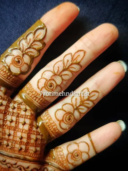 A close-up of floral cut-work on fingers, a beautiful and delicate technique.
