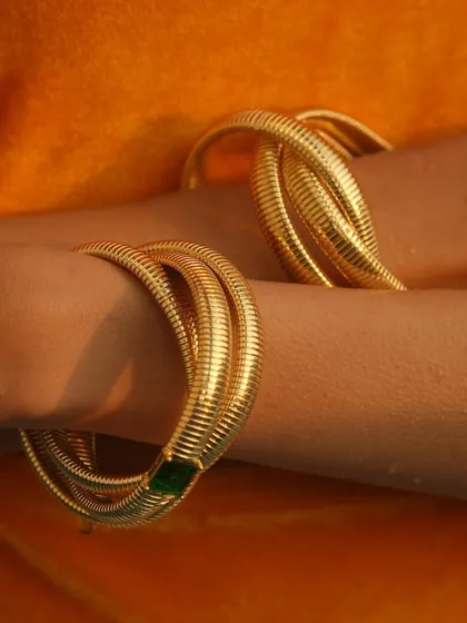 A close-up of my chunky layered twisted bangles, including the emerald version, perfect for a summer pool day.