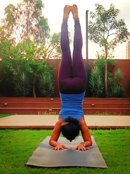 Finding my balance in Pincha Mayurasana, or Forearm Stand, outdoors. This inversion requires significant shoulder and core strength, and practicing on the grass adds an extra challenge for stability.