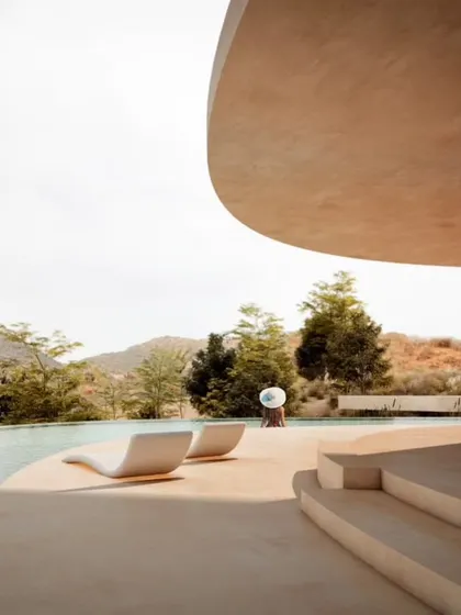 The pool deck at Amar Villa provides a luxurious space for relaxation, with uninterrupted views of the Udaipur mountains.