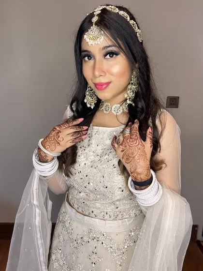 The full look, including the intricate mehndi and white bangles, which contrast beautifully with the glamorous makeup.