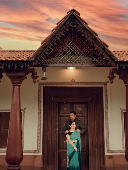 A stunning portrait in front of a traditional house under a dramatic sunset sky. We combine architecture and nature for breathtaking pre-wedding shots.