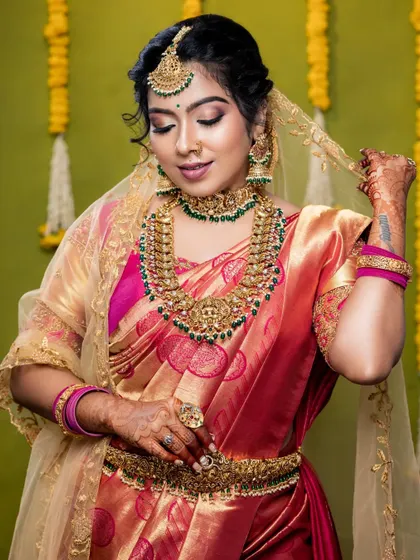 The complete look is a perfect blend of tradition and elegance. The jewellery is chosen to enhance her natural beauty and the richness of her saree.