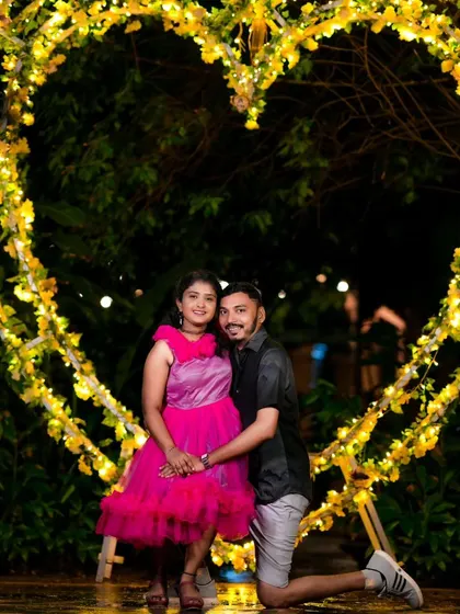 Posing in front of a large, heart-shaped floral arch at night. This setup provides a stunning backdrop for romantic pre-wedding photos.