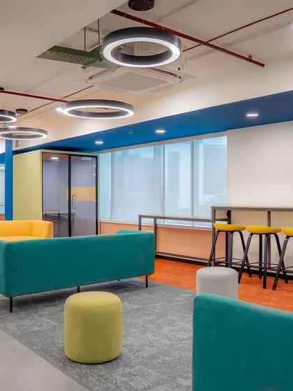 A duplicate view of the colorful breakout lounge, emphasizing the circular lighting fixtures and the mix of seating options that cater to different group sizes and activities.