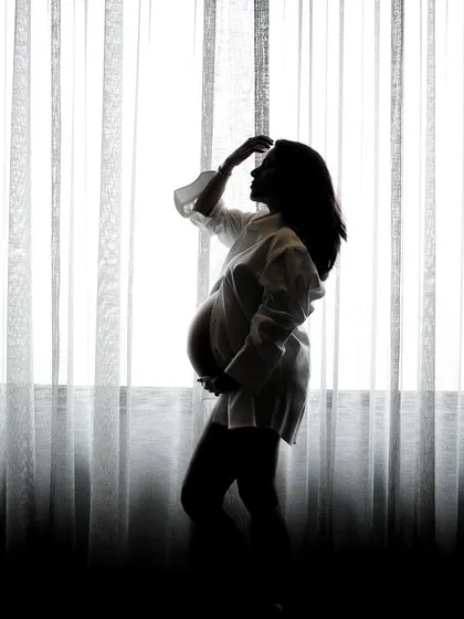 Another beautiful silhouette pose, capturing a moment of quiet reflection. These artistic shots are a popular choice for clients wanting something different from a standard maternity shoot.