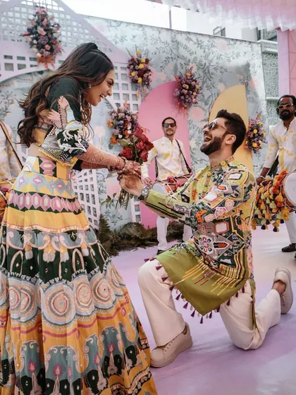 The groom gets down on one knee during the Haldi ceremony, a sweet and romantic gesture amidst the fun and playful atmosphere.