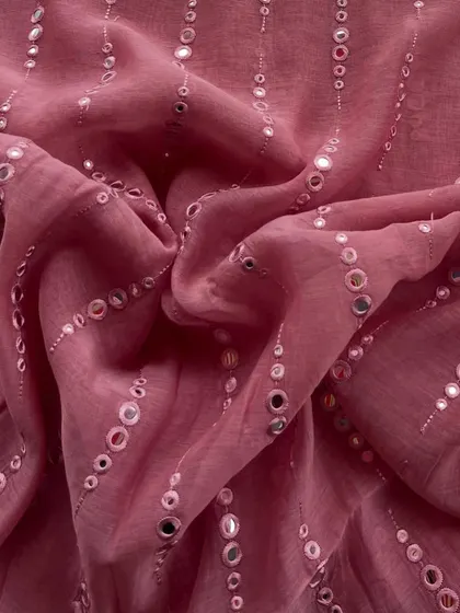 This mirror-work Mul Chanderi in a beautiful onion pink shade is made for celebration. The reflective mirrors add a festive sparkle to the delicate fabric.