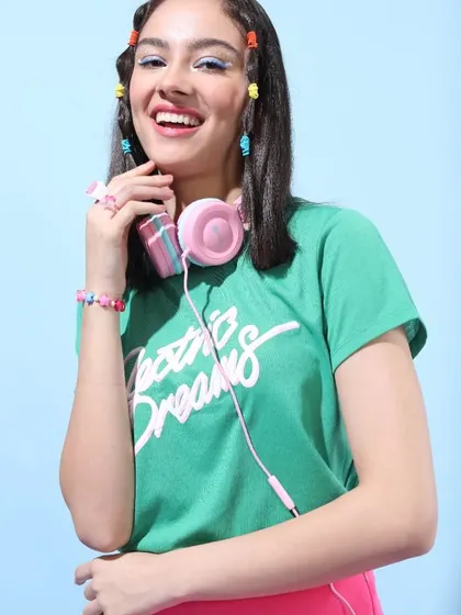 This look is all about color and fun. I styled a green "Electric Dreams" tee with bright pink shorts and playful accessories like beaded bracelets and headphones.