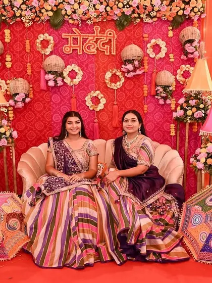 The bride and her mother posing in front of the vibrant mehendi stage, a beautiful memory from the 'Piyu ki Shaadi' celebrations.