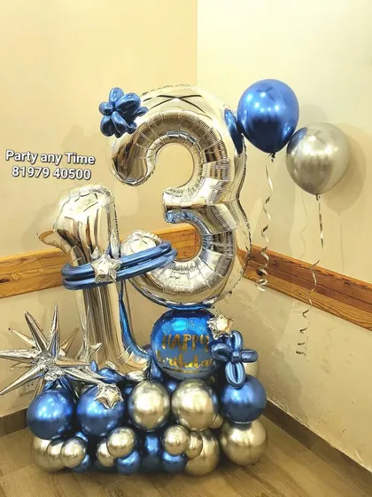 A 13th birthday balloon bouquet in silver and blue chrome, with a starburst accent.