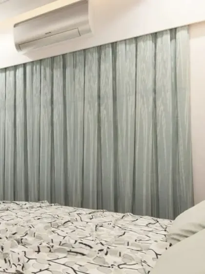 A close-up view of the bedroom, showing the sheer curtains that allow for soft, natural light.