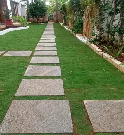 Hardscaping is key to a well-designed garden. This image shows a long stone pathway that provides a durable and stylish walkway through the lawn.
