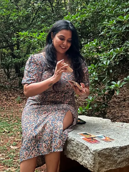 Who else is ready to shuffle, cut, and reveal? A photo to celebrate World Tarot Day, with me sitting on a stone bench in nature, cards in hand, ready for the magic to unfold.
