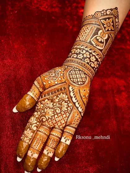 A single hand adorned with a full-coverage bridal design. This piece is packed with a variety of patterns, including checks, florals, and paisleys, demonstrating versatility in traditional artistry.