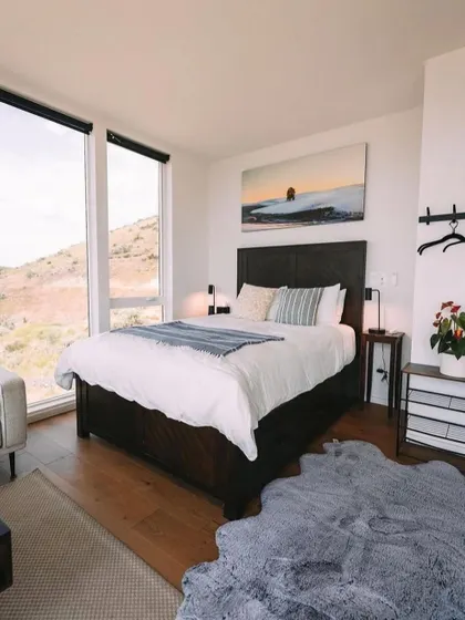 A bedroom with a view. I design spaces that frame the natural beauty outside, making the landscape a part of the interior decor.
