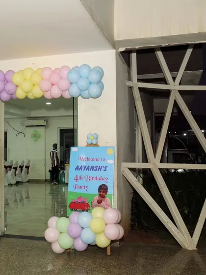 A cheerful pastel balloon arch and welcome sign for Aayansh's 4th birthday party.