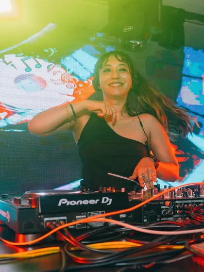 A candid shot capturing my joy while playing a high-energy set. Connecting with the audience through music is the best part of my job as a female DJ.