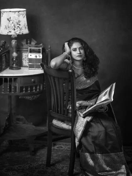 The storybook scene with Narayani and her radio, rendered in black and white. This version feels even more nostalgic, like a still from a classic black and white film. The textures of the room and her saree are beautifully highlighted.