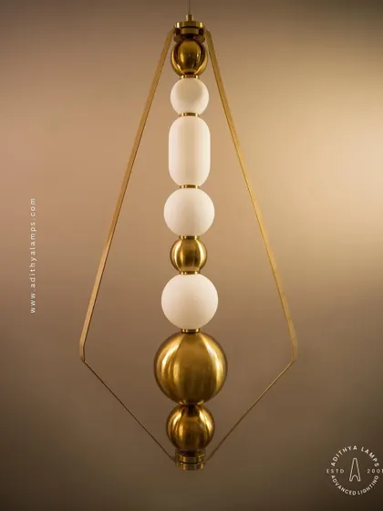 This elegant pendant is framed by a triangular gold structure, enclosing a string of white and gold beads. It's a sophisticated and modern piece that adds a touch of jewelry-like decoration to your space.