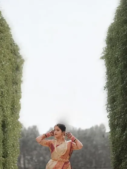 An artistic shot of the bride standing between two tall hedges, creating a powerful and dramatic composition.