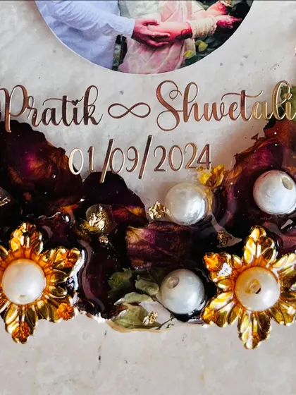 A cute, budget-friendly photo frame made using an engagement garland. The preserved flowers and pearls create a lovely border around the couple's photo.