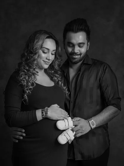 A hint of what’s to come. In this black and white photo, the couple looks down at a tiny pair of baby shoes they are holding together over the bump, a sweet and symbolic pose.