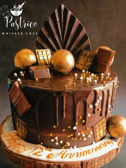For the true chocolate aficionado, my chocolate overload cake is pure indulgence. It's a rich Dutch truffle cake with a dark chocolate drip, topped with chocolate spheres, bars, and a handcrafted chocolate fan.