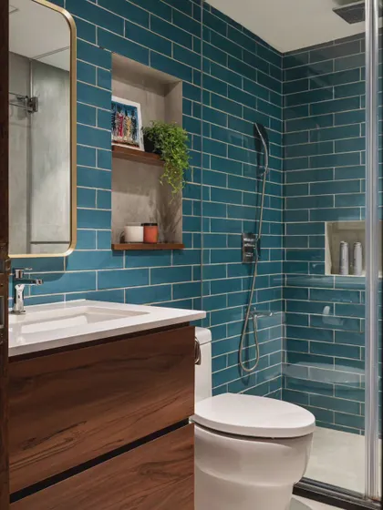 A bathroom can be a place to experiment with color and pattern. The vibrant teal subway tiles in this design bring so much life to the space, balanced by the warmth of the wooden vanity. It’s a functional room that doesn’t sacrifice style.