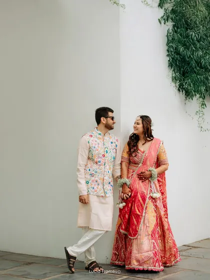 A stylish portrait of the couple against a minimalist white wall, their colorful outfits popping.