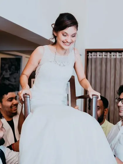 The bride's smiling face as she is lifted high during the Hora dance, a moment of pure exhilaration and fun.