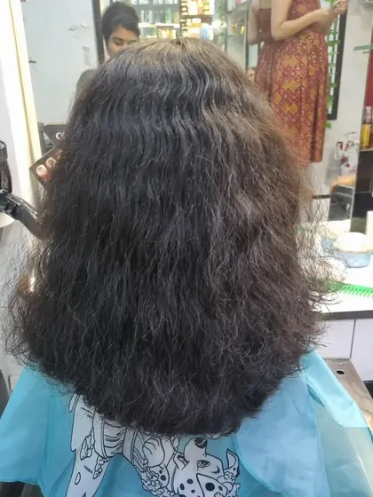 A classic U-cut for this young client. It's a simple yet neat style that helps maintain length while giving the hair a clean, defined shape.