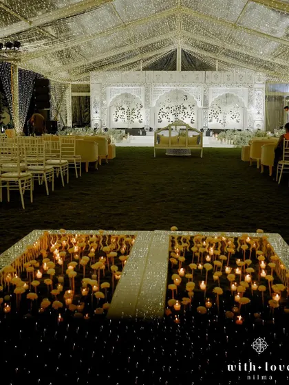 A unique dance floor created with a bed of candles and paper flowers, reflecting the shimmering Thikri work stage. This detail added a layer of romance and magic to the sangeet night, creating a truly memorable experience.